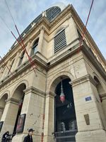 (2026) Zoom sur les arches au premier étage de l’Opéra de Lyon côté de la place de la Comédie. On peut voir la plaque « Mémoire de Lyon » en bas à droite de la photo.